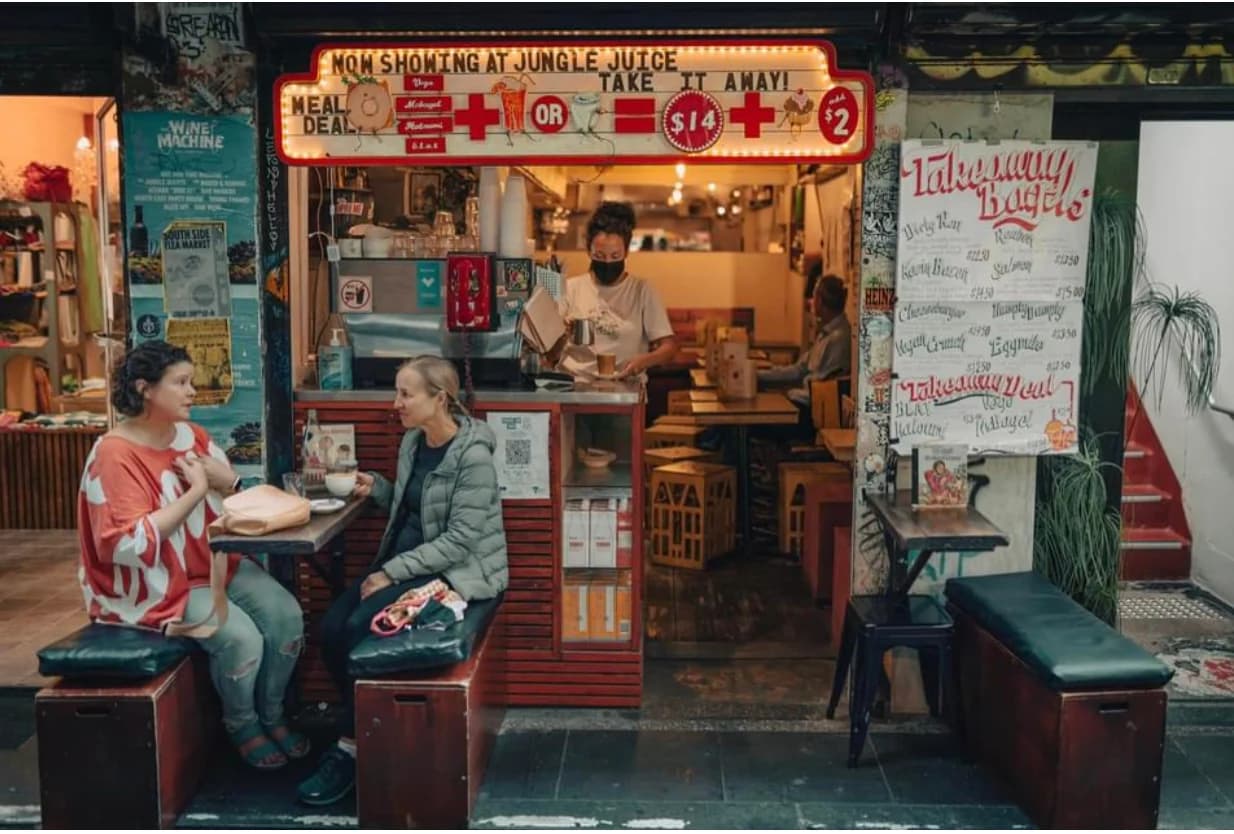 Customers seated outside Jungle Juice while café staff work behind the counter
